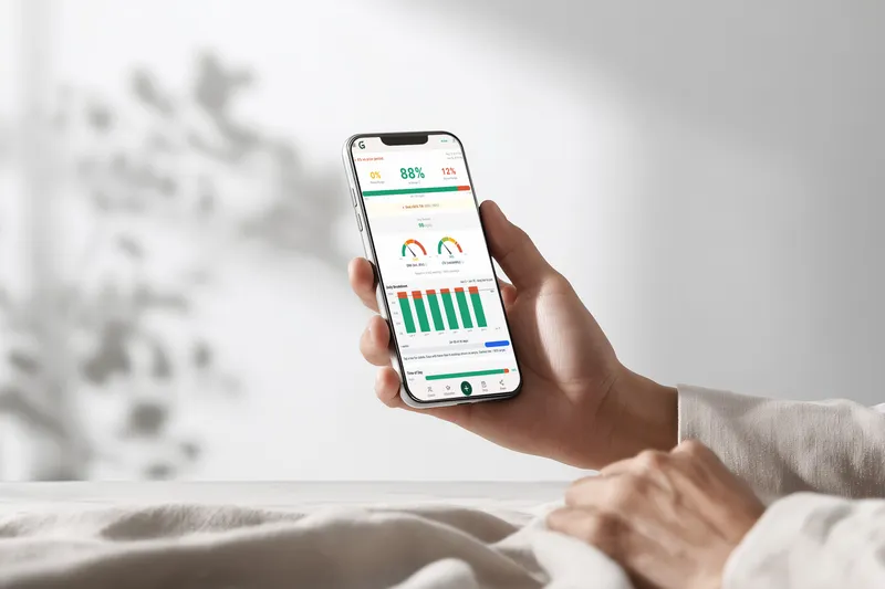 Hand holding a phone showing the Glyvance app glucose dashboard — 88% in range, daily breakdown chart, and glucose metrics